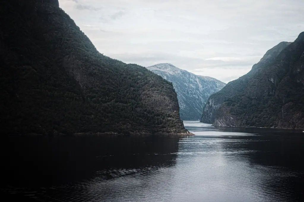 Rolig norsk fjord omgitt av bratte fjell